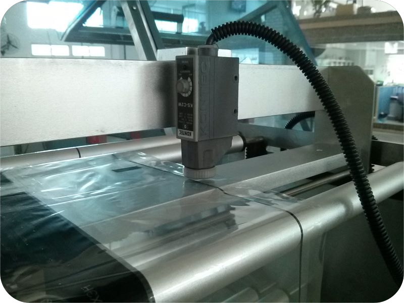 Cảm biến Eye-Mark trên máy bọc màng co giúp nhận diện vạch màu và căn chỉnh chính xác vị trí in trên bao bì